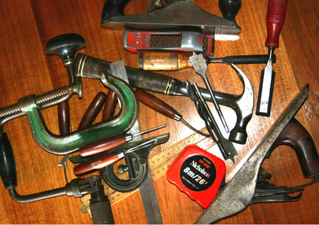 Woodworking tools laid out on a wooden workbench