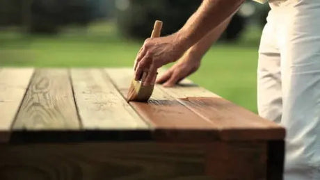 Applying wood oil by hand to bare timber with a cloth