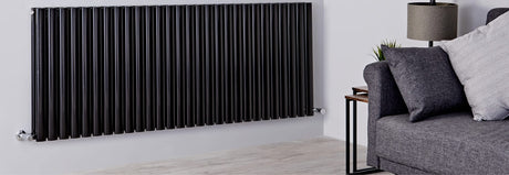Matt black vertical radiator in a modern living room