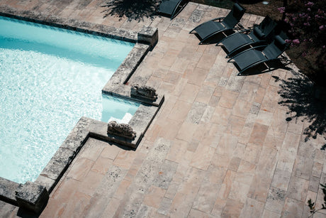 Large tiled patio terrace with rows of sun loungers, showing the scale of a paved outdoor area before jointing
