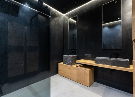 Minimalist bathroom with black walls and a black sink for a bold monochrome look