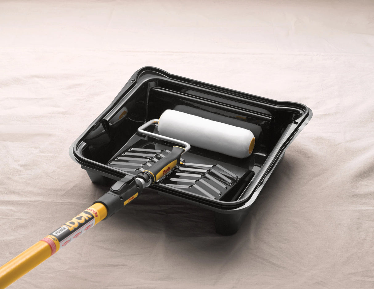 Purdy roller sleeve loaded in a paint tray on a frame with extension pole ready for use
