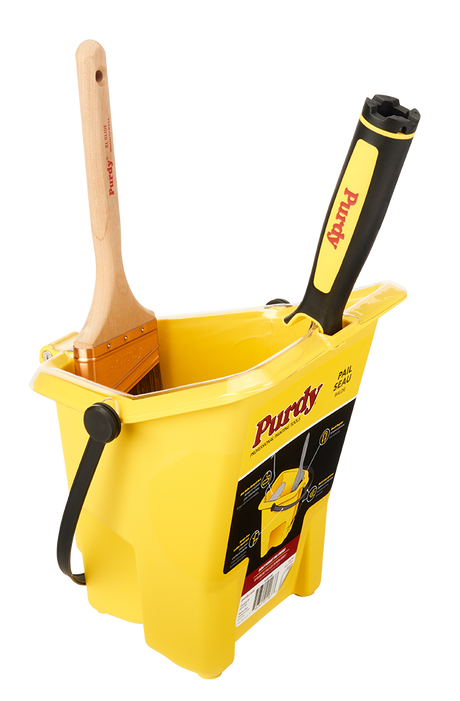 Purdy Pail with a paintbrush resting on the integrated magnet and a mini roller on the ramp