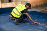 Worker using a brush to work carpet cleaning foam into a soiled carpet