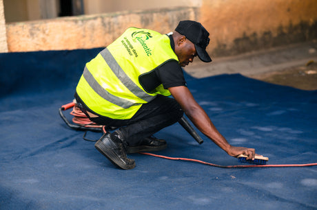 Worker using a brush to work carpet cleaning foam into a soiled carpet