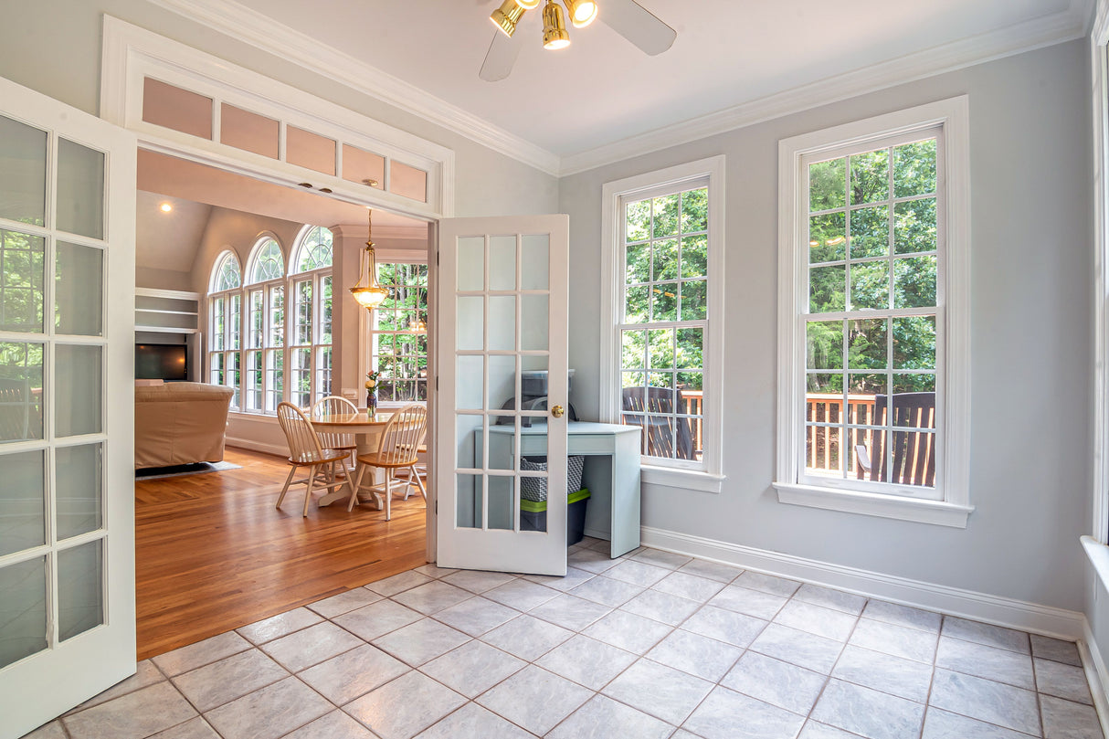 Bright living area with white-framed doors and warm neutral walls