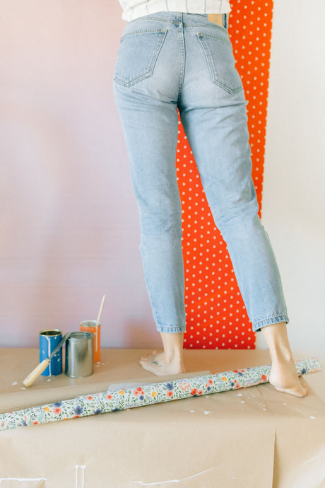 Person applying patterned wallpaper to a wall