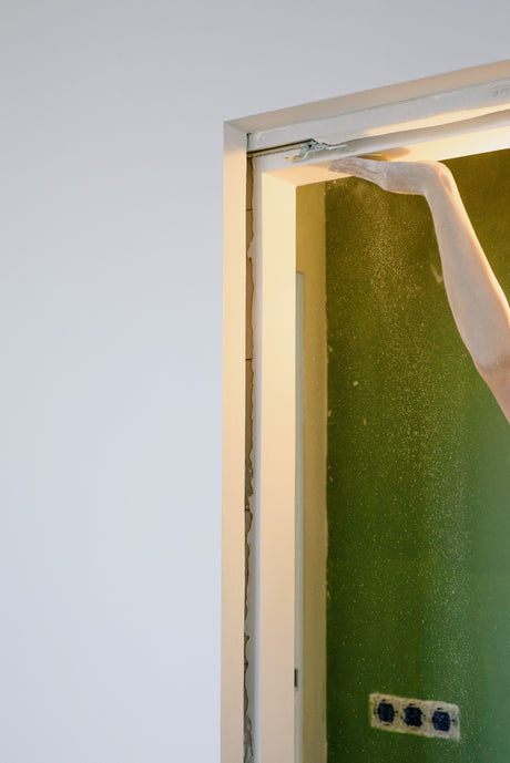Person preparing a door frame before painting