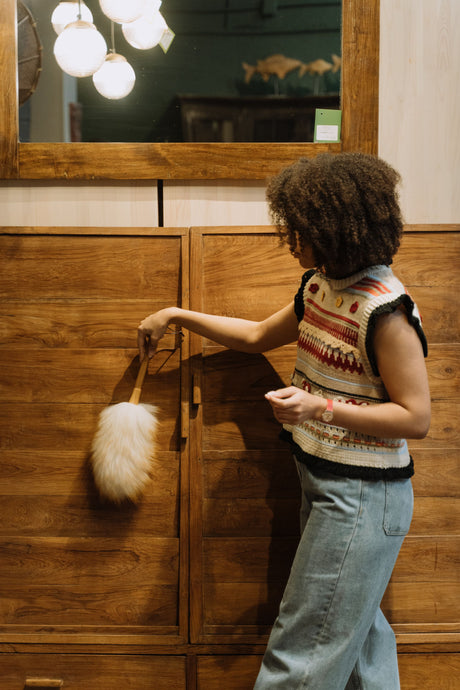 Person dusting a wood surface before applying paint