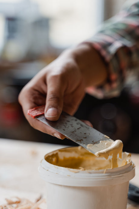 Craftsman using a small angled blade knife for precise filler application