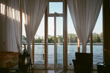 White-framed glass doors and windows with warm wood flooring in a cosy neutral room