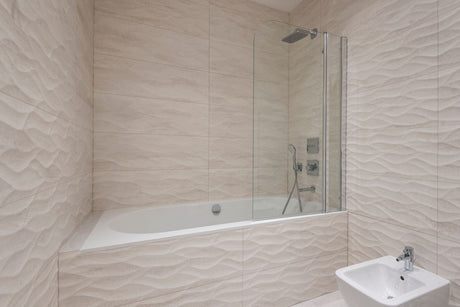 Sleek modern bathroom with beige textured tiles and bathtub, complementing Dulux Egyptian Cotton