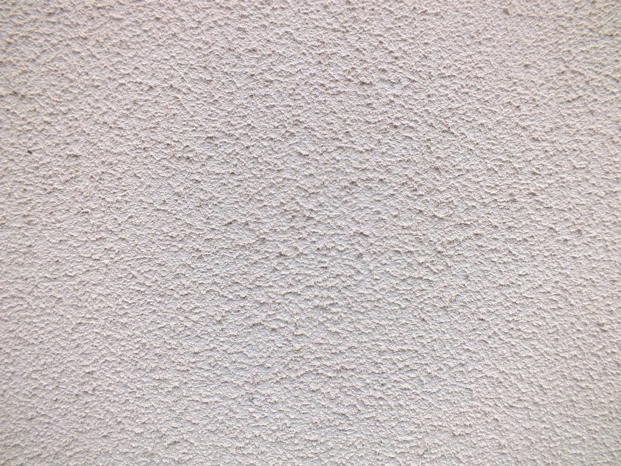 Close up of a textured white render wall surface suited to the Purdy Colossus 9 inch roller sleeve