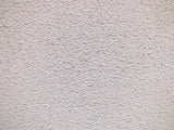 Close up of a textured white render wall surface suited to the Purdy Colossus 9 inch roller sleeve