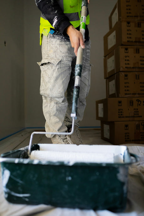 Decorator rolling paint onto a textured interior wall with a Purdy Colossus style roller sleeve