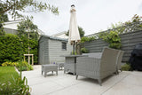 Traditional grey paving slab patio in a garden setting with outdoor furniture