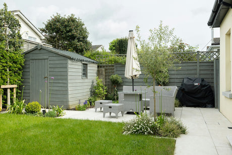 Classic mid grey garden patio slabs with table and chairs, typical British back garden paving