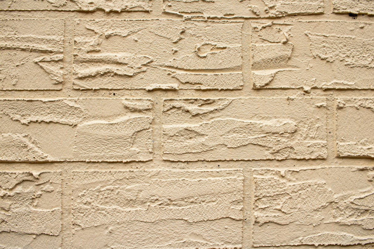 Close up of a textured beige brick masonry wall suited to the Purdy Colossus 18 inch 1/2 inch nap roller sleeve
