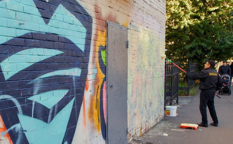 Person rolling paint over a brick masonry wall, similar to work suited to the Purdy Colossus 18 inch 3/4 inch nap sleeve