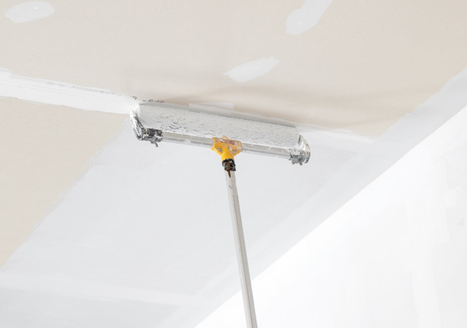 Decorator using a Purdy extension pole and roller frame to paint a ceiling